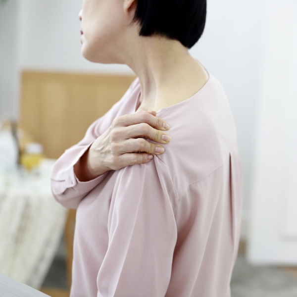 어꺠를 부여잡고 통증을 호소하는 중년 여성