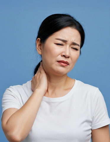 목 통증으로 목을 짚고 찡그린 표정을 짓는 여성